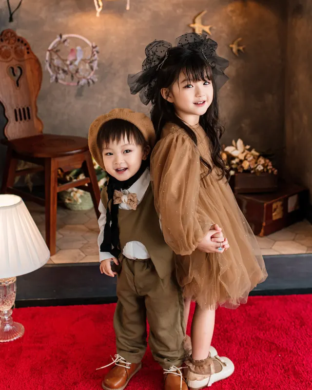 黒いチュールのリボンを付けた女の子と、帽子の男の子