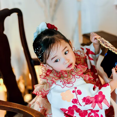フリル衿の着物で椅子に座る3歳の女の子