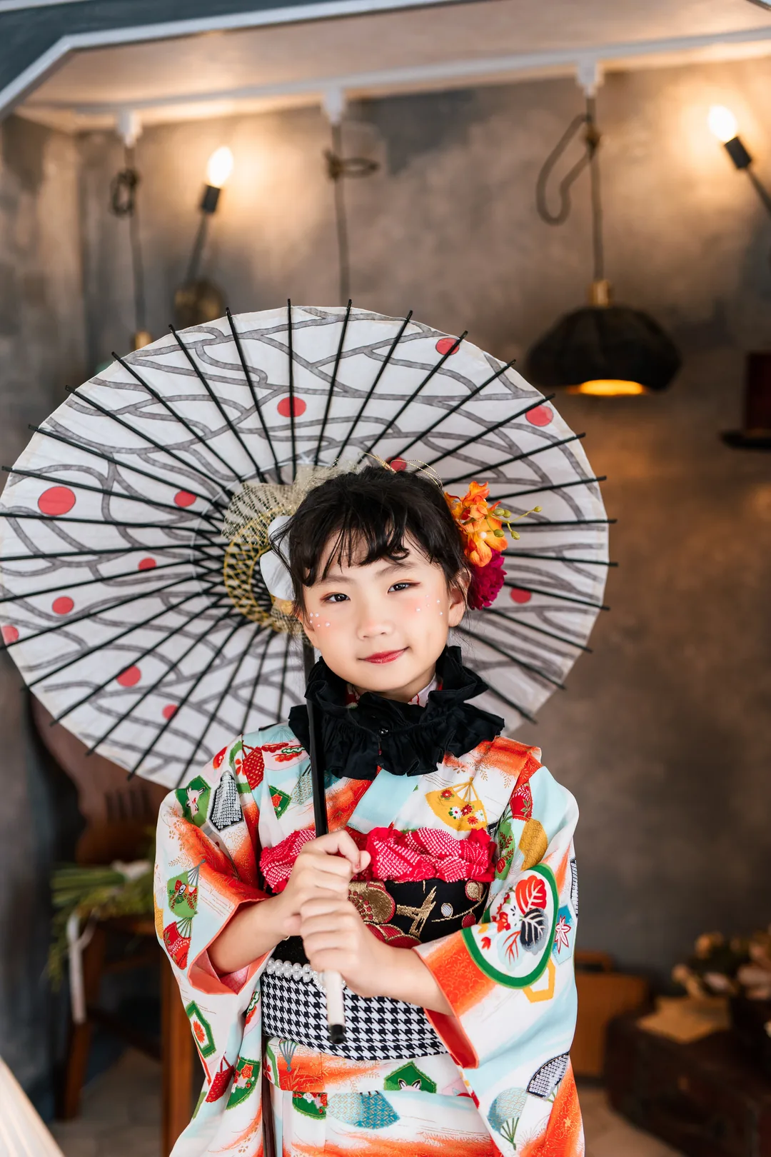 帽子屋で番傘をさす、白地に扇の着物の女の子