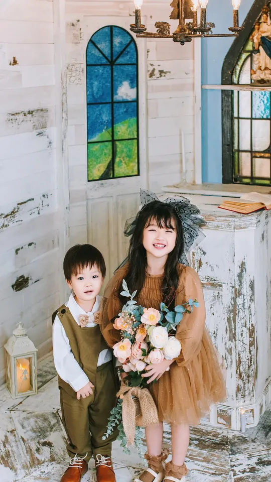 礼拝堂のベンチに座る、洋装の子どもふたり